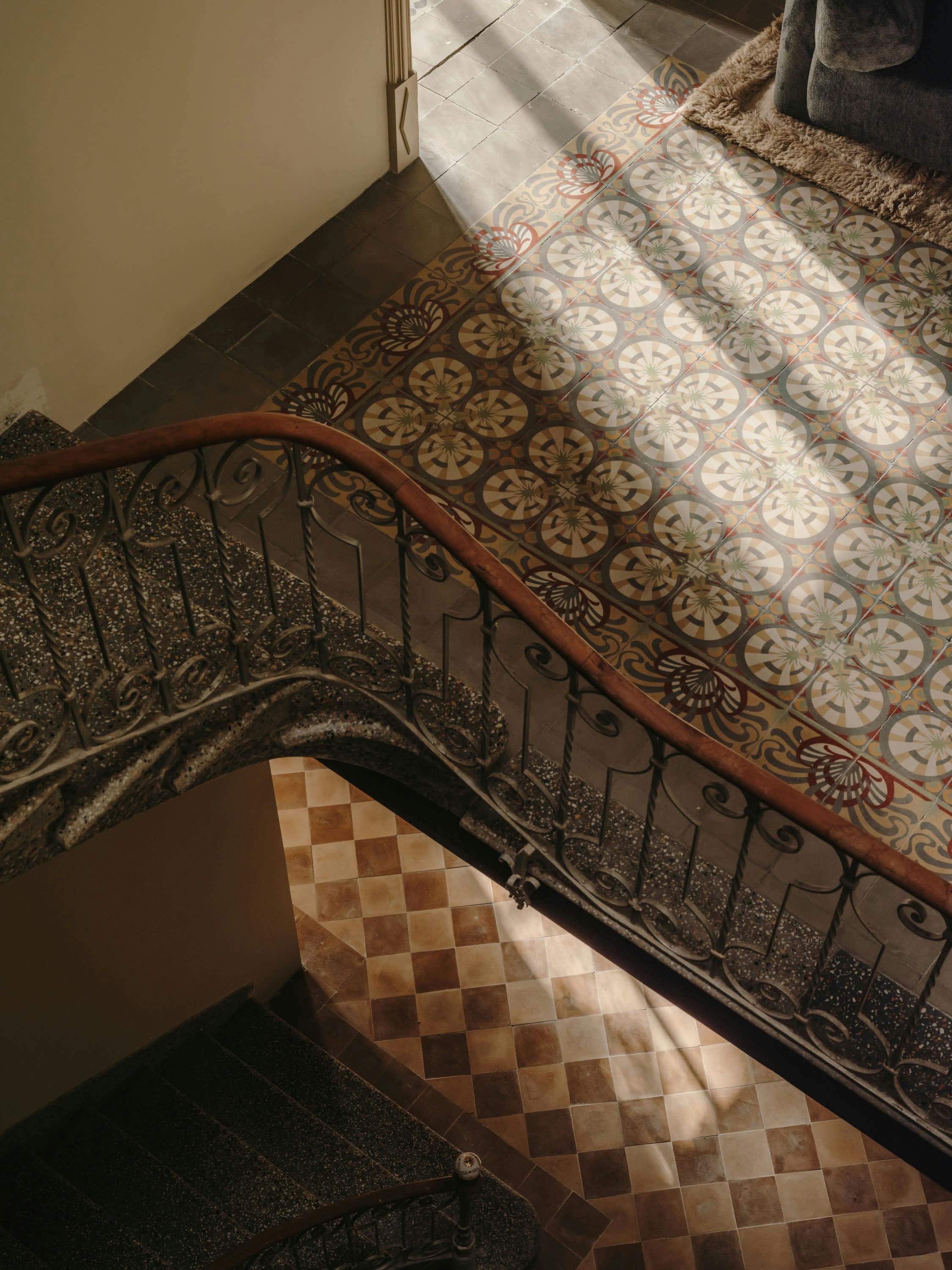 The image features a staircase with a metal railing, which is situated in a room with a tiled floor. The staircase is located in the corner of the room, and the tiled floor is visible in the background. The room appears to be a small space, possibly a bedroom or a small living area.

The staircase is surrounded by a beautifully designed tiled floor, which adds a touch of elegance and style to the room. The tiled floor is also visible in the background, creating a visually appealing contrast between the staircase and the tiled floor.