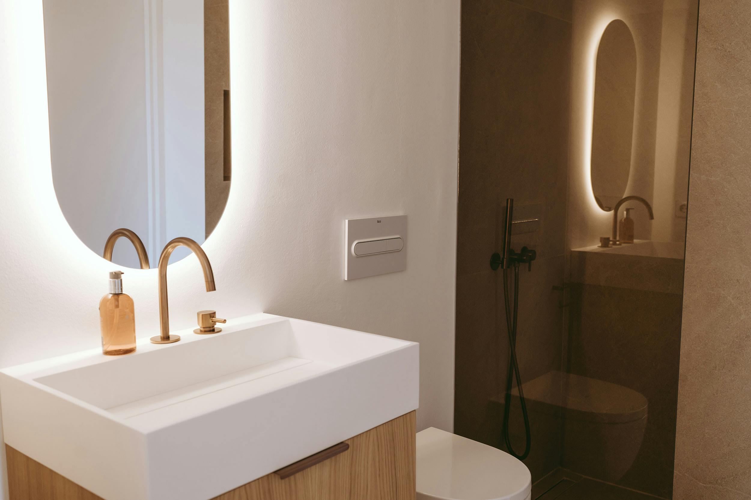 The image features a clean, modern bathroom with a white sink, a mirror, and a shower stall.