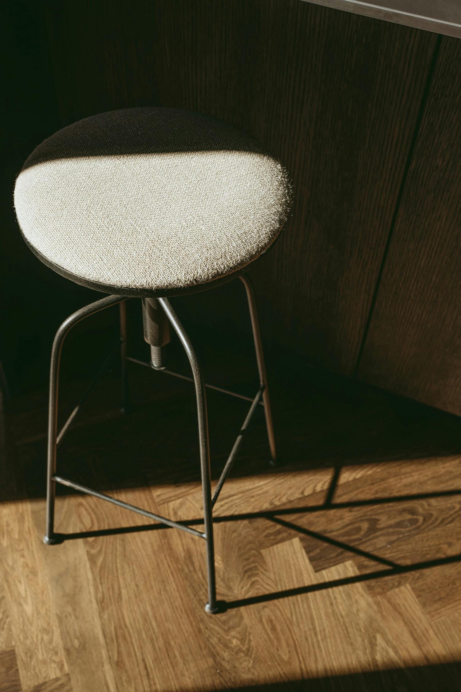 A white chair is placed on a hardwood floor in a room with a wooden floor, creating a contrast between the chair and the floor.