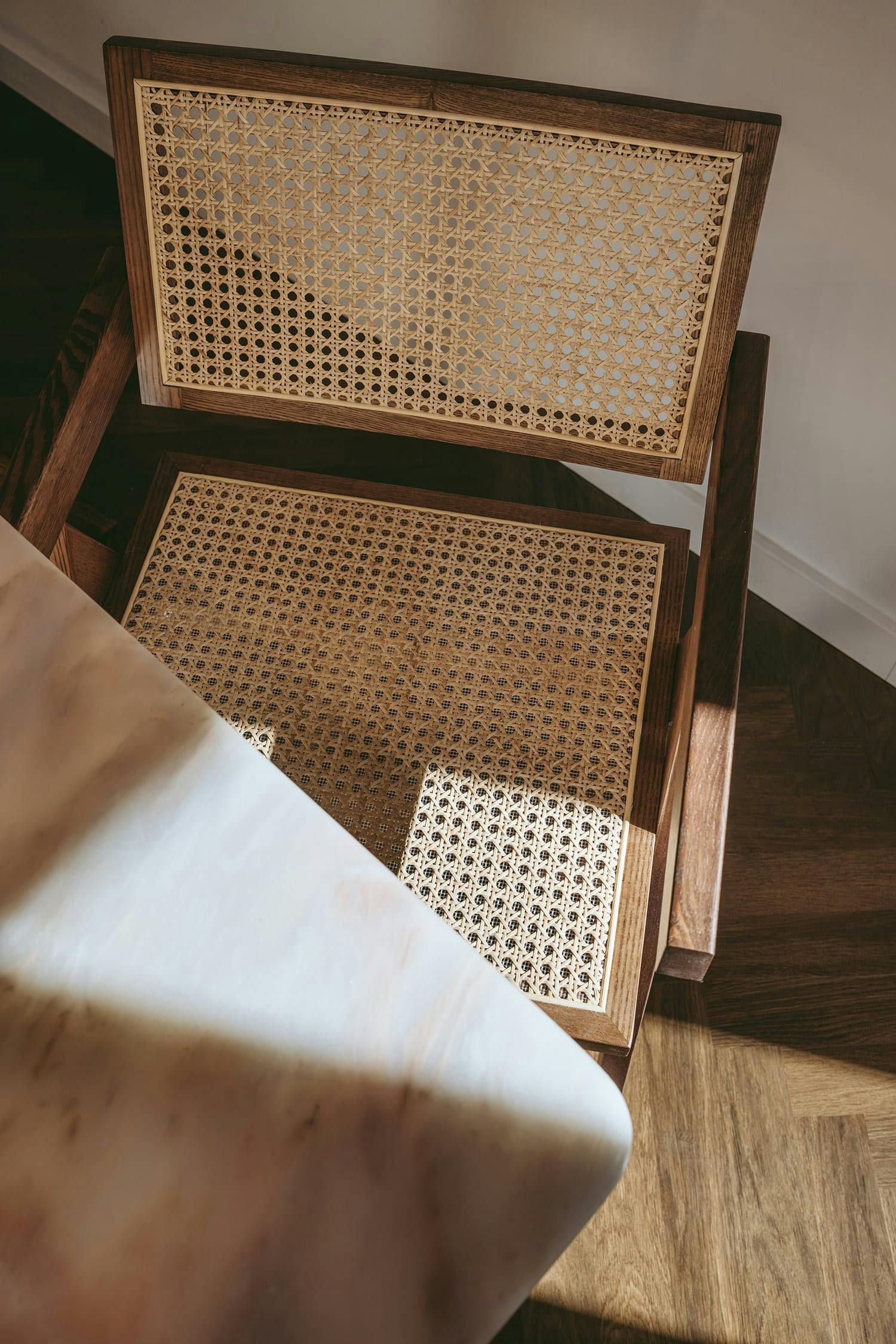 The image features a wooden floor with a chair placed in the middle of it.