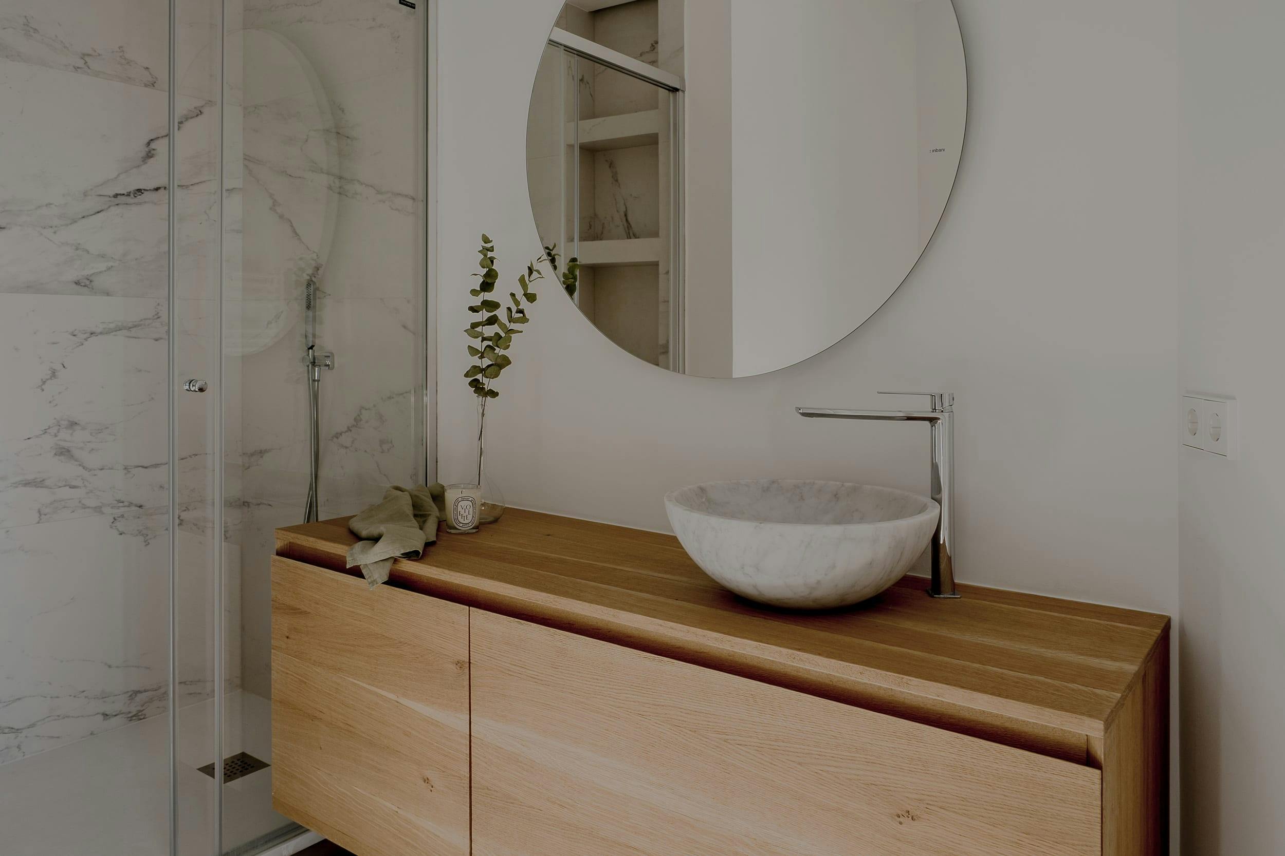 The image features a modern bathroom with a white sink, a large mirror, and a wooden vanity.