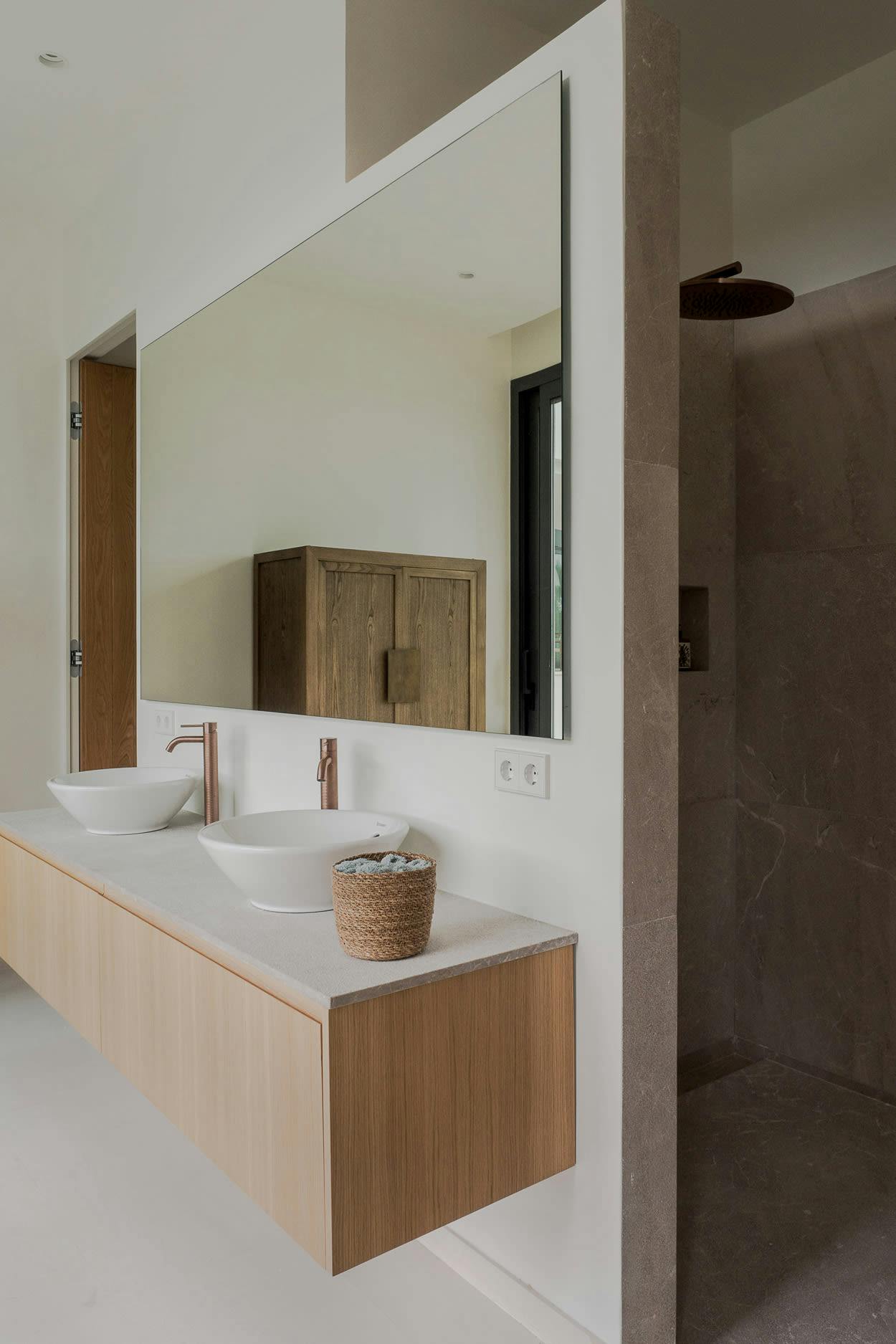 The image features a large bathroom with a double sink vanity, a mirror, a wooden cabinet, and a large mirror.